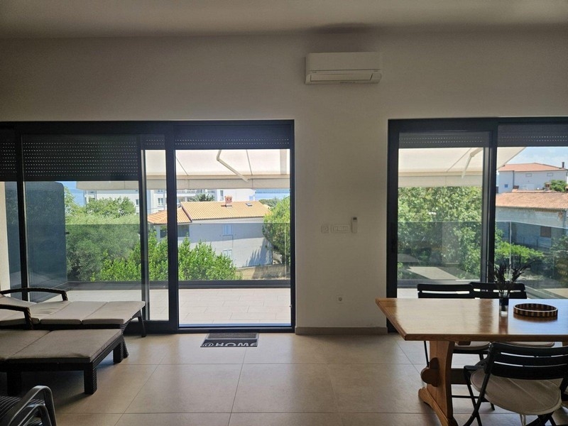 Dining area with wooden table and view of balcony and sea