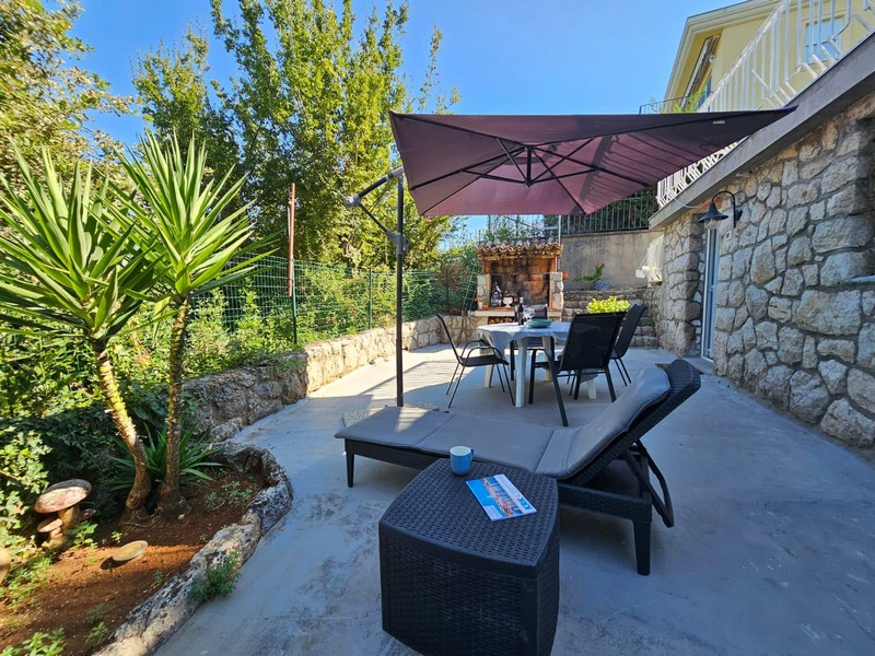 Terrace with lounge and parasol of the ground floor apartment in Njivice