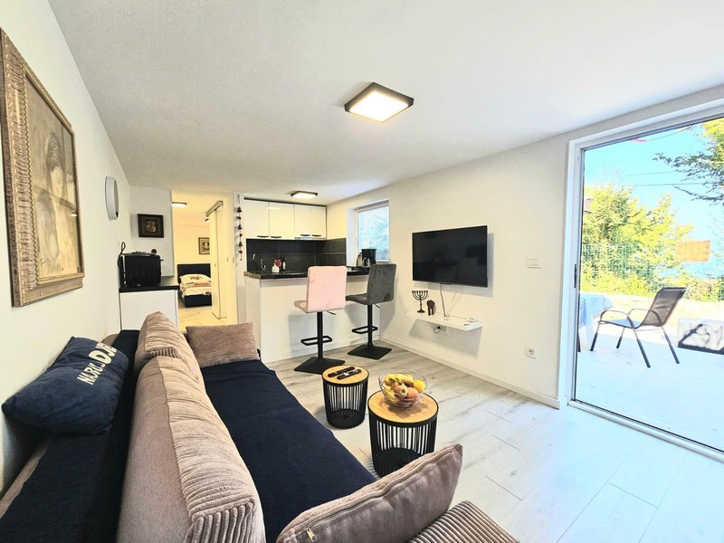 Living area with sofa and exit to the terrace in Njivice
