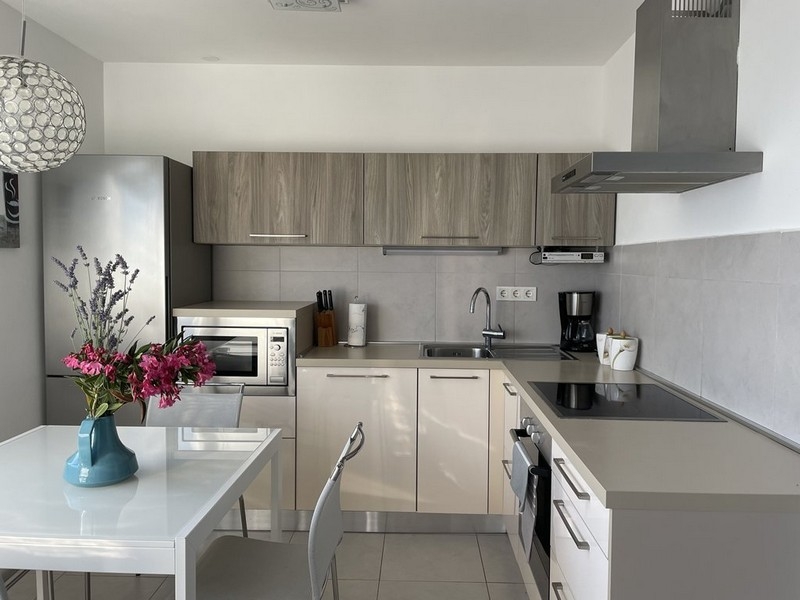 Modern kitchen with white fitted kitchen in the apartment in Murter