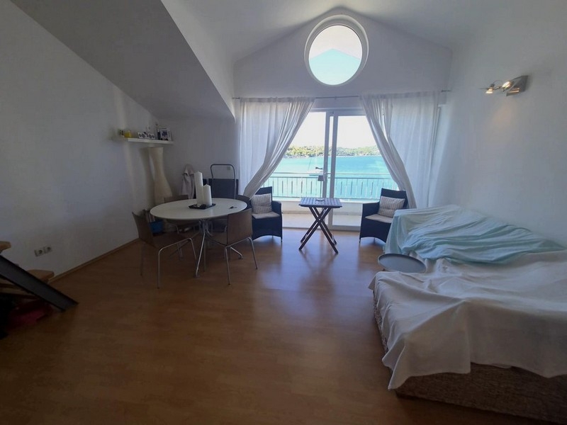 Bright living room under the sloping roof with a round window