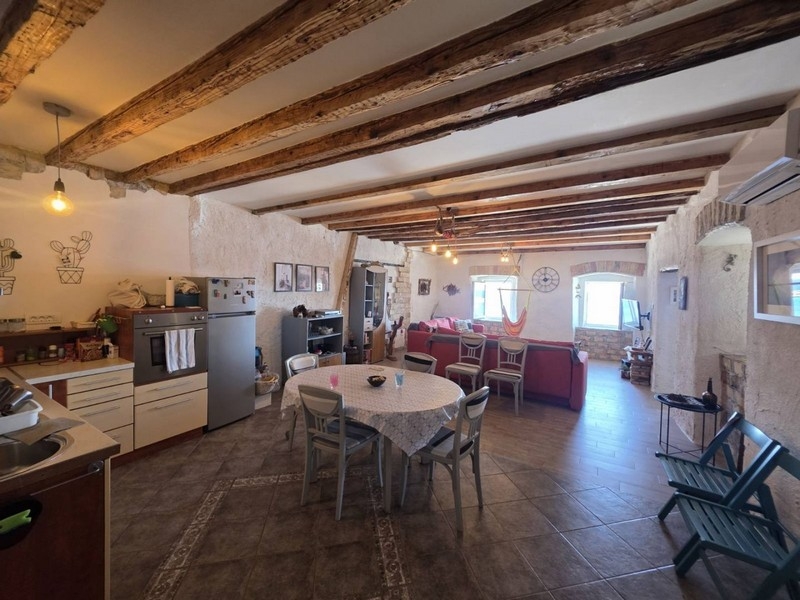 Living and dining area with wooden beamed ceiling in the apartment in Senj