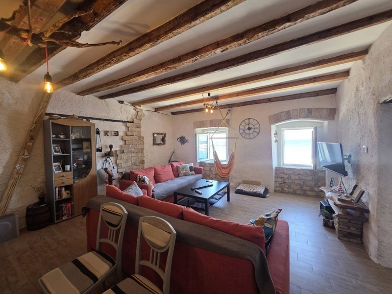 Open living room with sofa and wooden beams