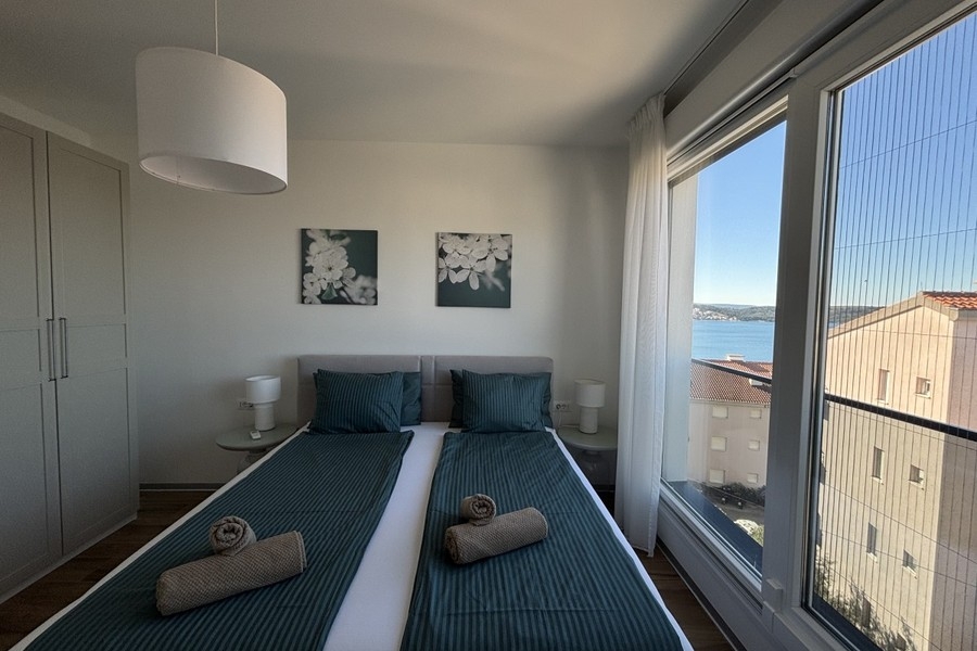 Bedroom with window and view of the sea in Trogir