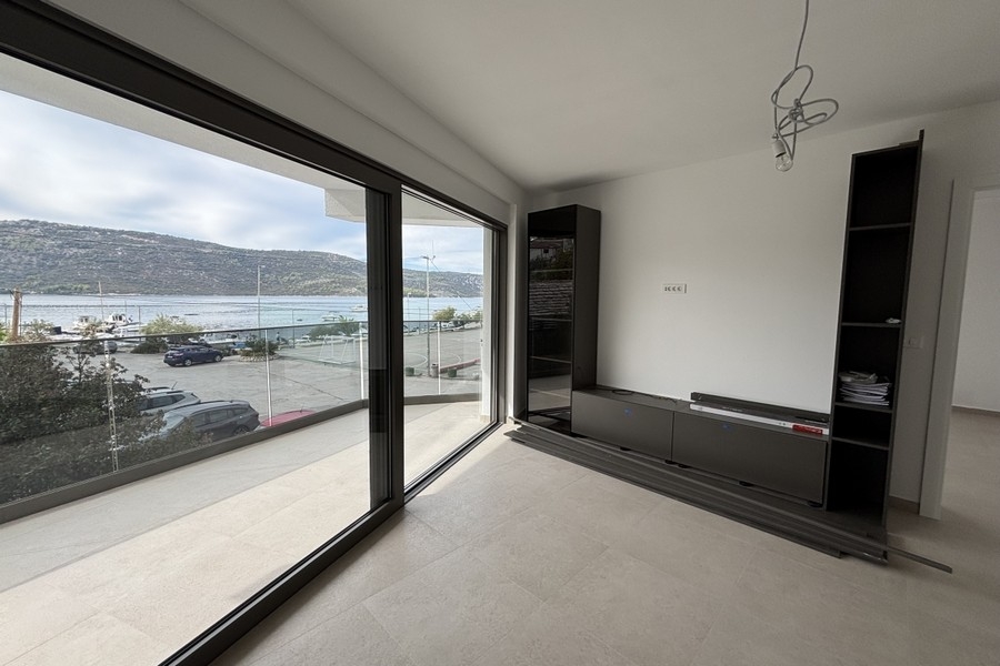 Living area with floor-to-ceiling balcony door and sea views