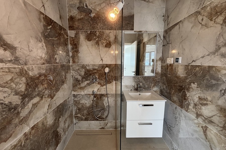 Bathroom with shower and marble tiles