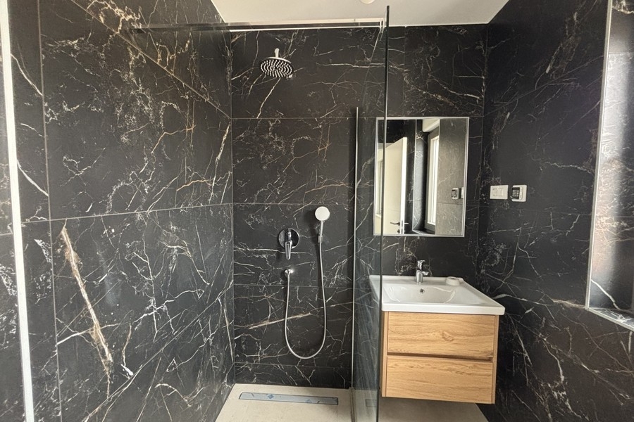 Bathroom with walk-in shower and wooden vanity
