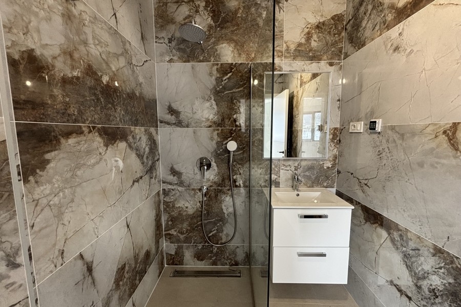Another bathroom with light natural stone tiles