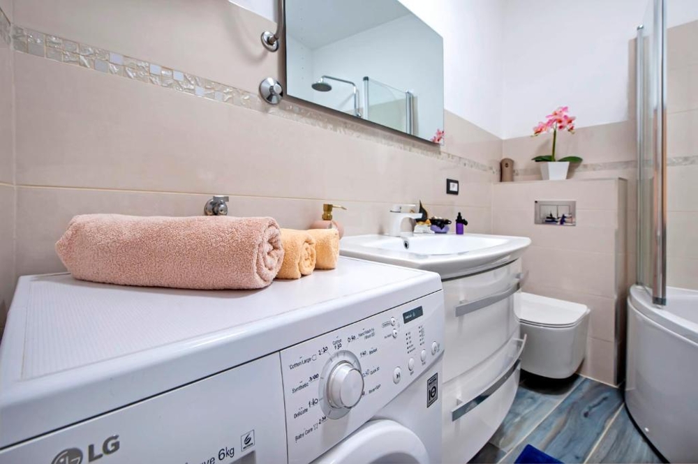 Bathroom with bathtub and washing machine