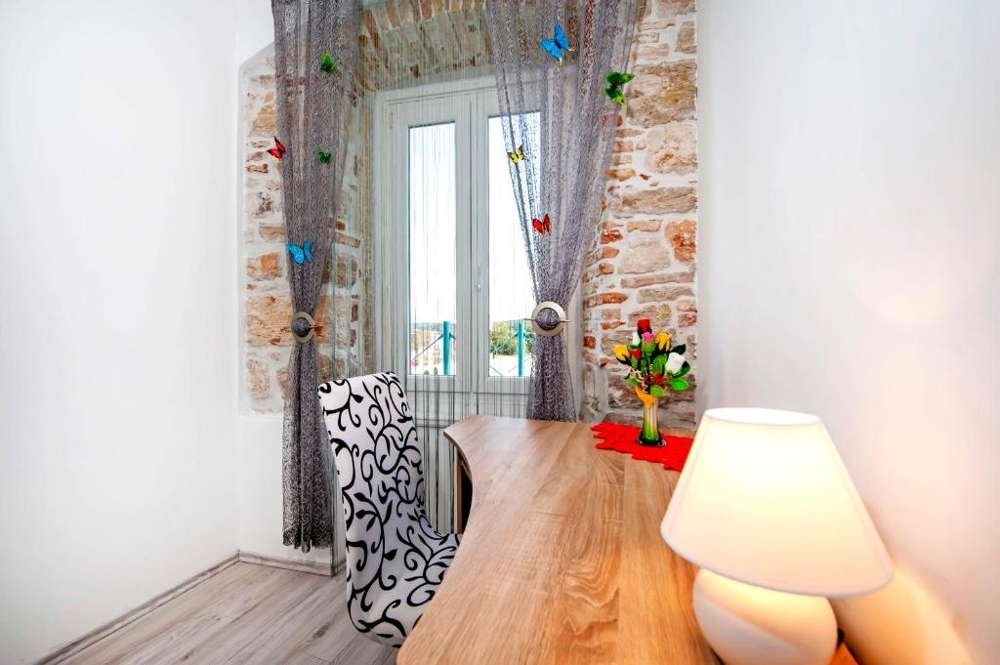 Desk by the window in front of the natural stone wall