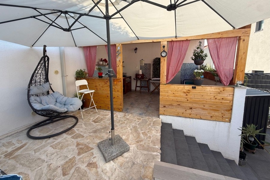Summer kitchen with seating area and hanging chair in the garden
