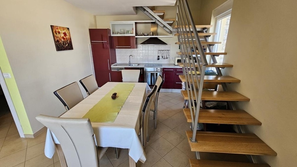 Dining area with kitchen and stairs to the attic