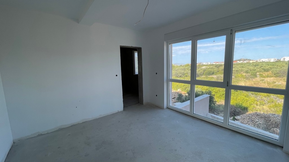 Room with a large window front and a view of the greenery