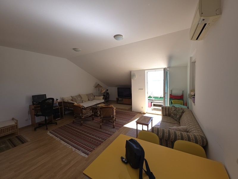 Living room with seating area and dining table under the sloping roof