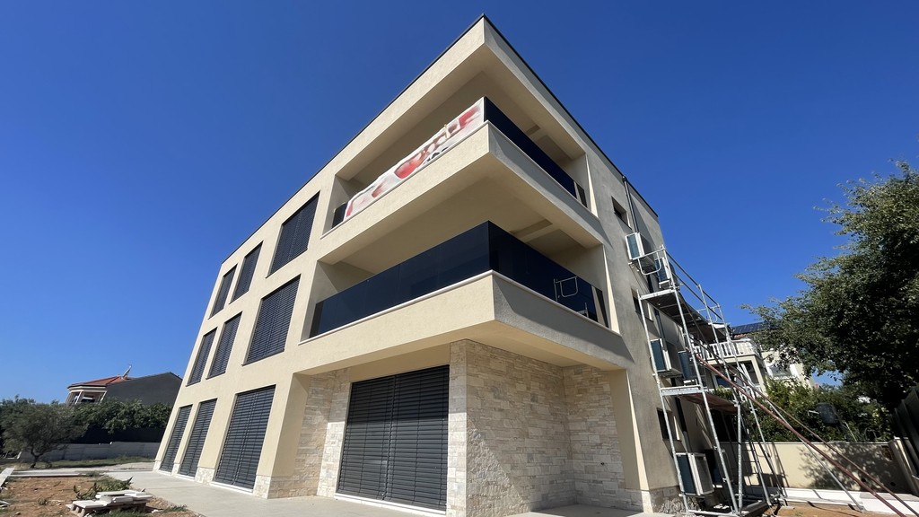 Residential building with natural stone base and terraces