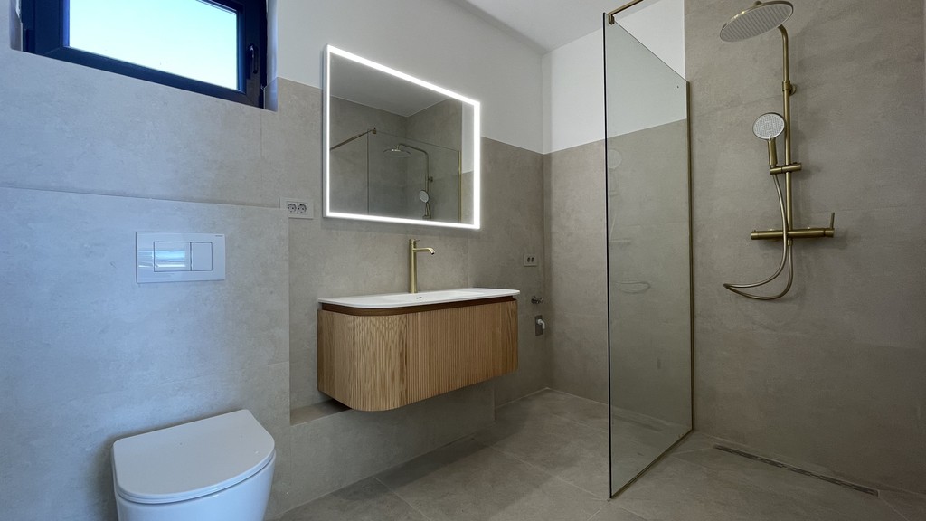 Bathroom with rain shower and illuminated mirror
