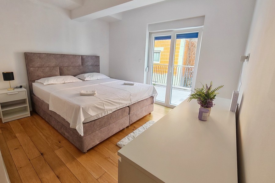 Bedroom with double bed and wooden floor