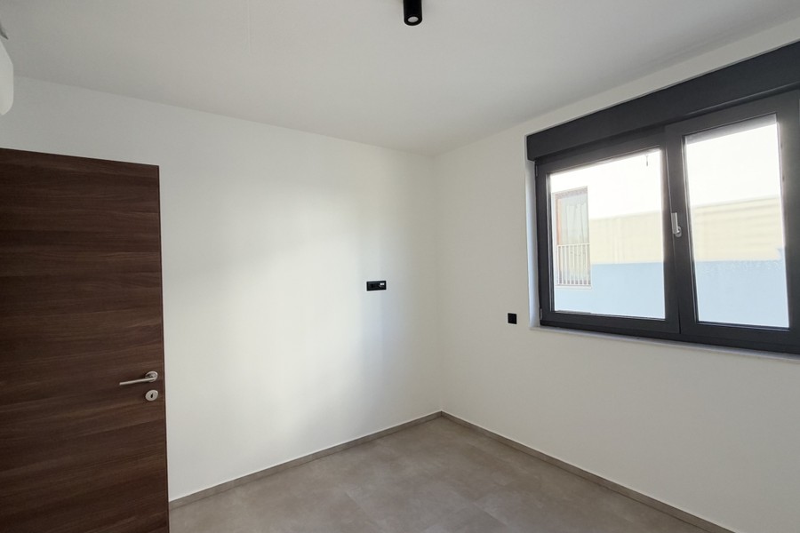 Bedroom with wooden door and window facing the street