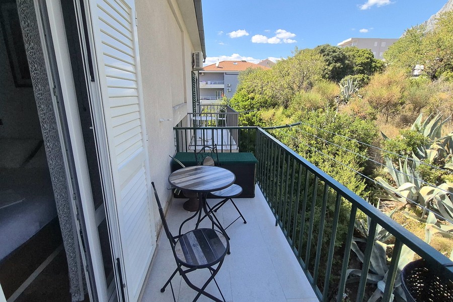 Balcony with bistro table and view of greenery