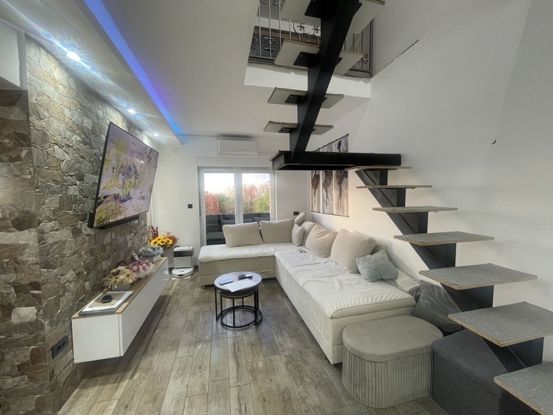 Living room with corner sofa and open staircase