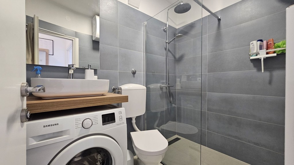 Bathroom with shower and washing machine