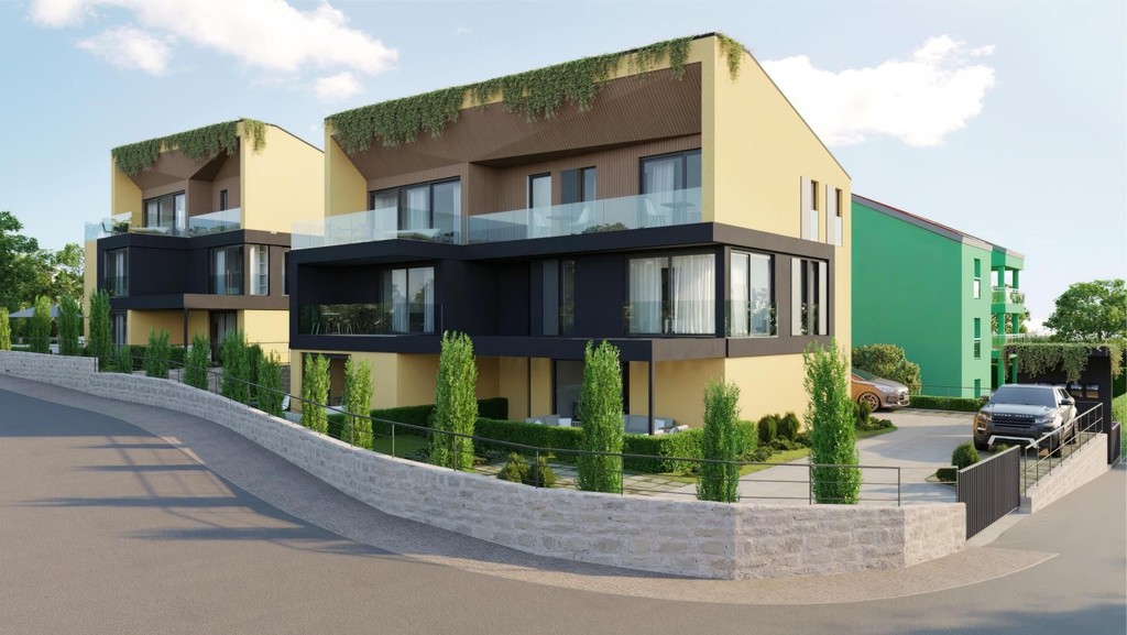 New-build houses with glass balconies and green roof edges along the street