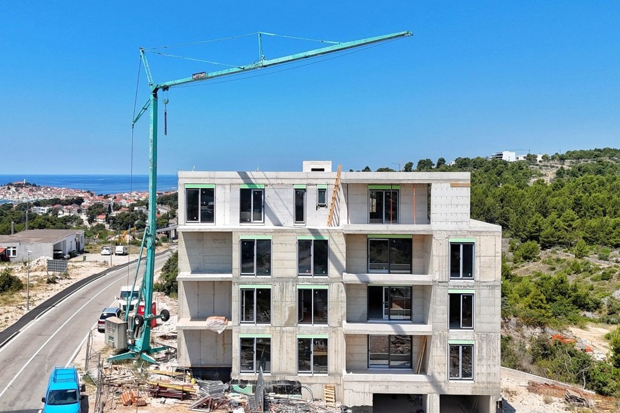 Construction site with crane, old town by the sea on the left