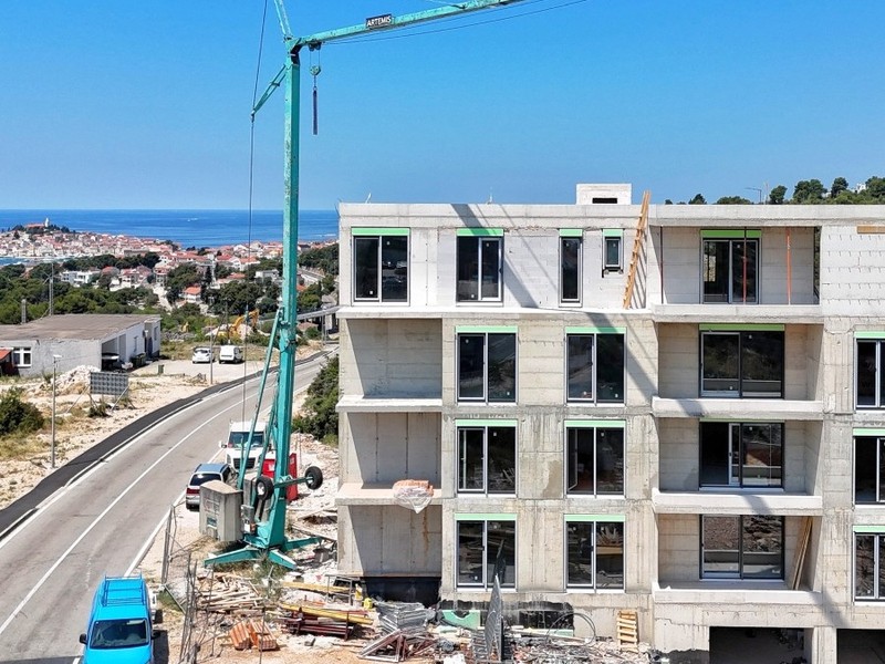 Construction site with crane, old town by the sea behind