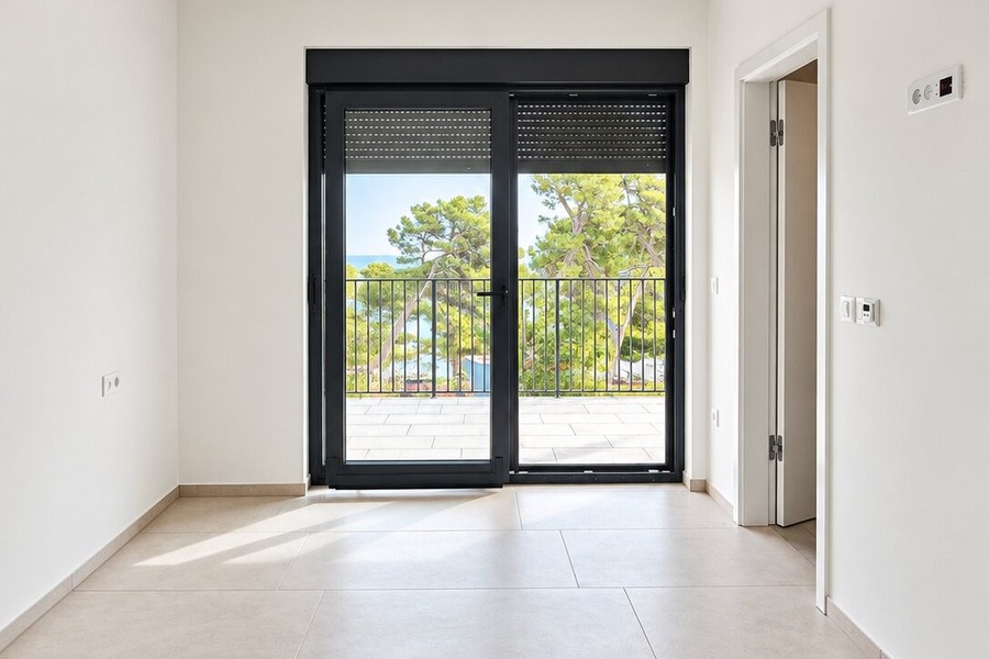 Bedroom with balcony door and view of greenery