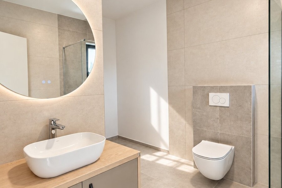 Bathroom with illuminated round mirror