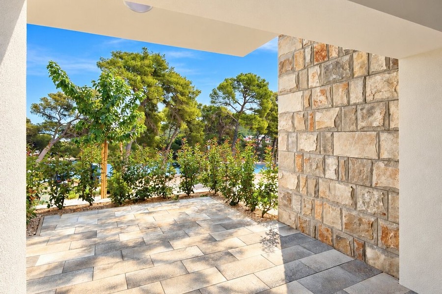 Covered terrace with view through the pine trees to the sea