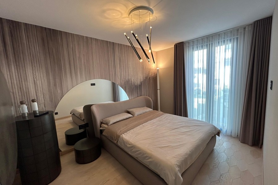 Bedroom with upholstered bed and designer lighting