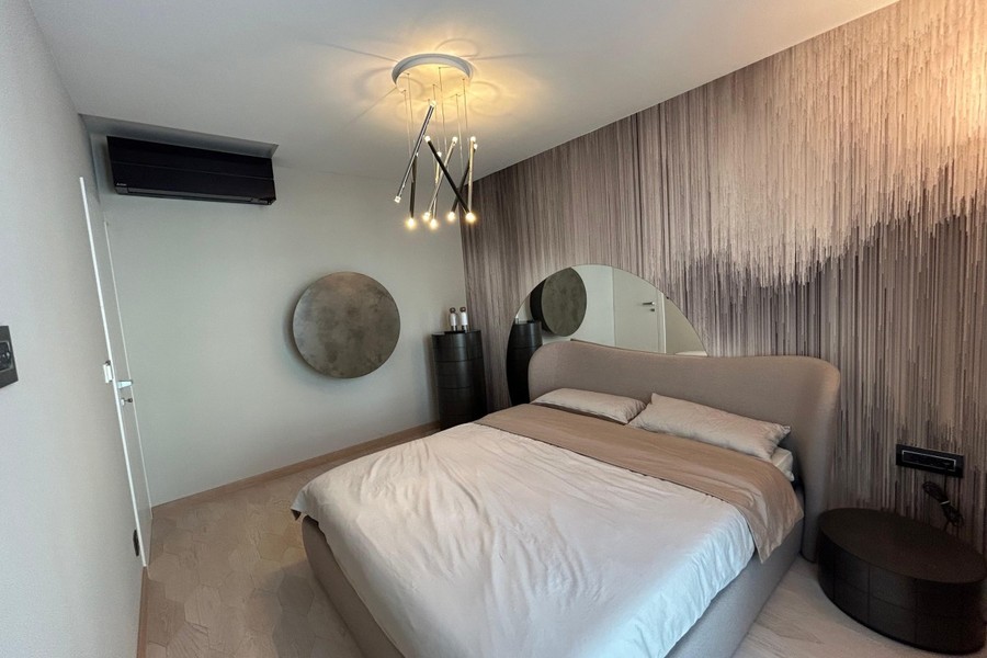 Bedroom with air conditioning unit and round mirror