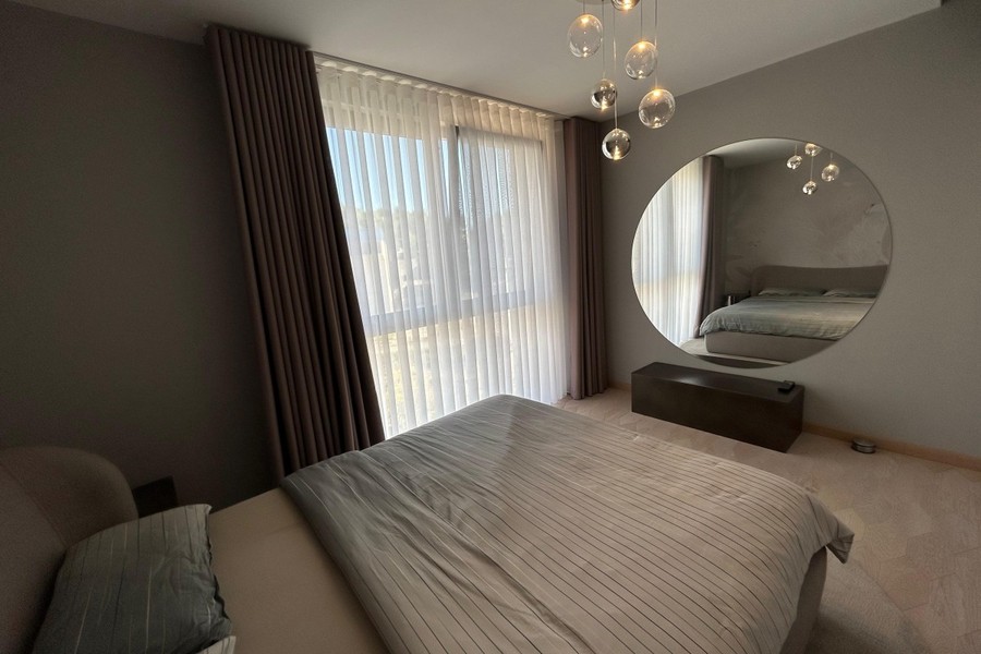 Bedroom with wall mirror and curtains