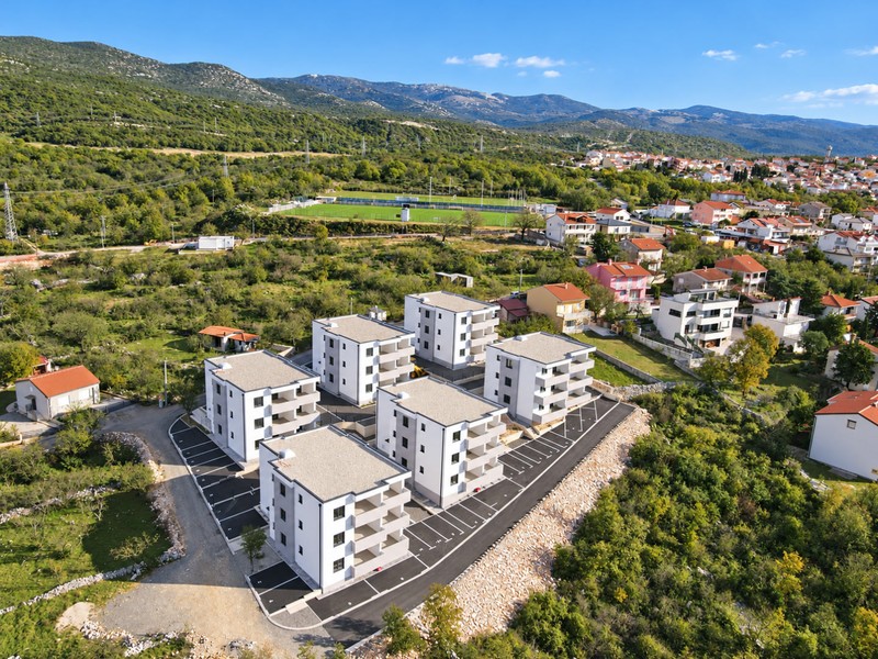 New buildings with a sports ground and mountains