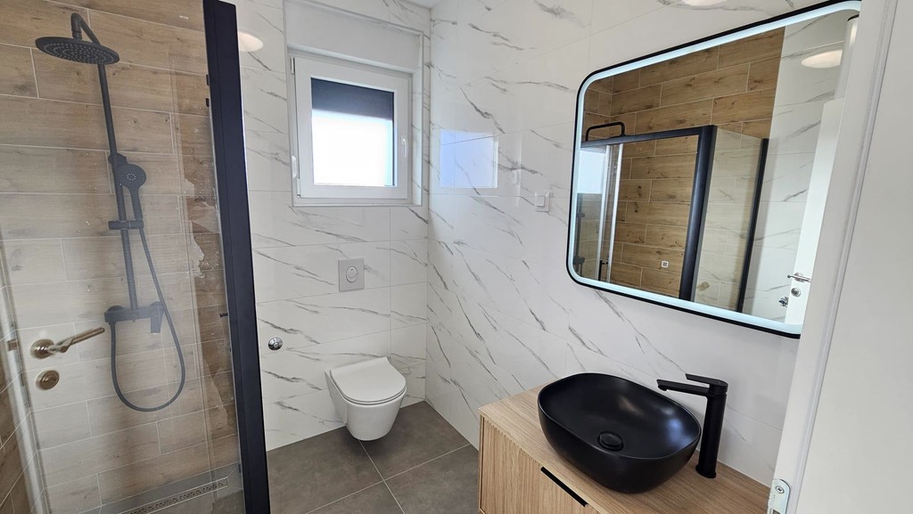 Bathroom with shower and wall mirror