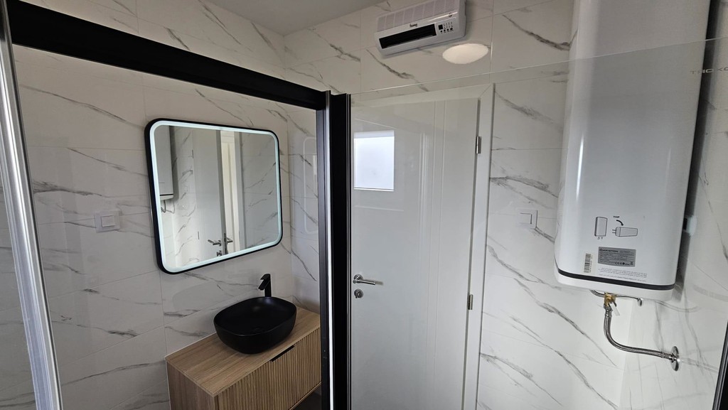 Bathroom with water heater and washbasin