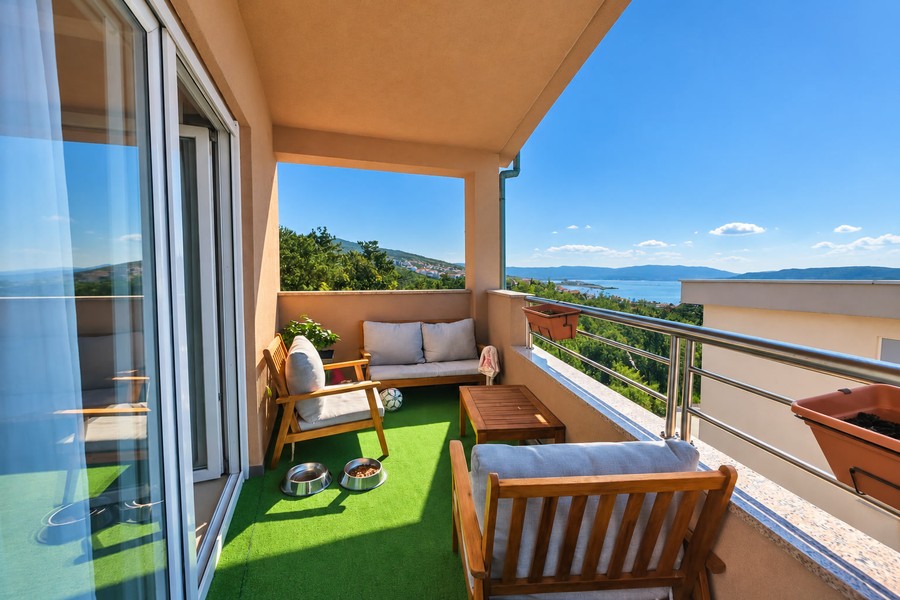 Balcony with wooden furniture and view of the sea