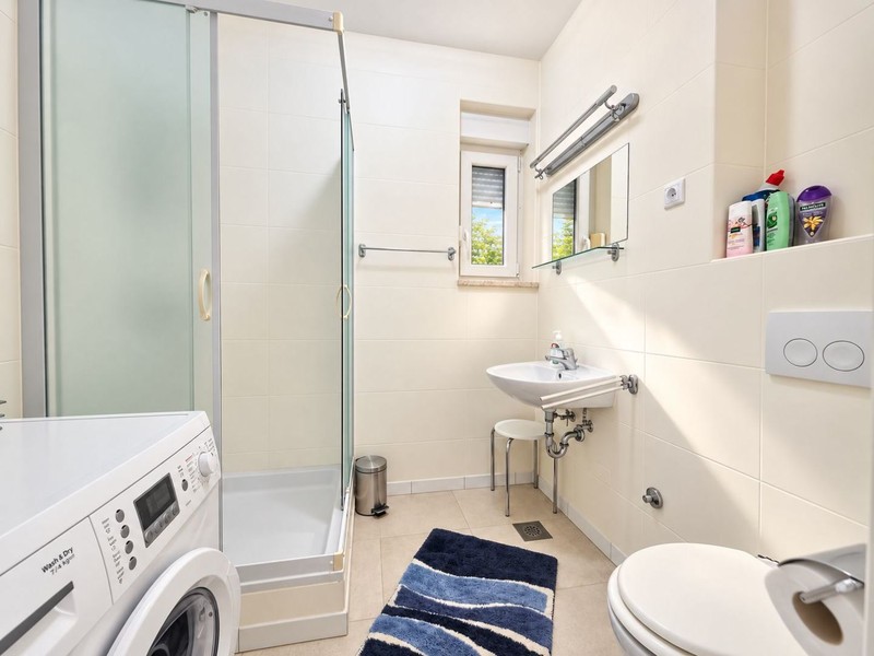 Bathroom with shower and washing machine