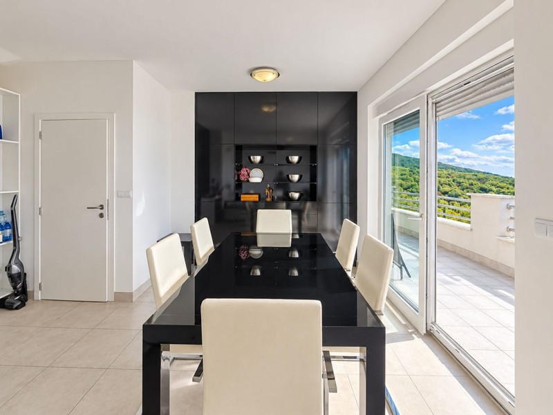 Dining table with white chairs and terrace door
