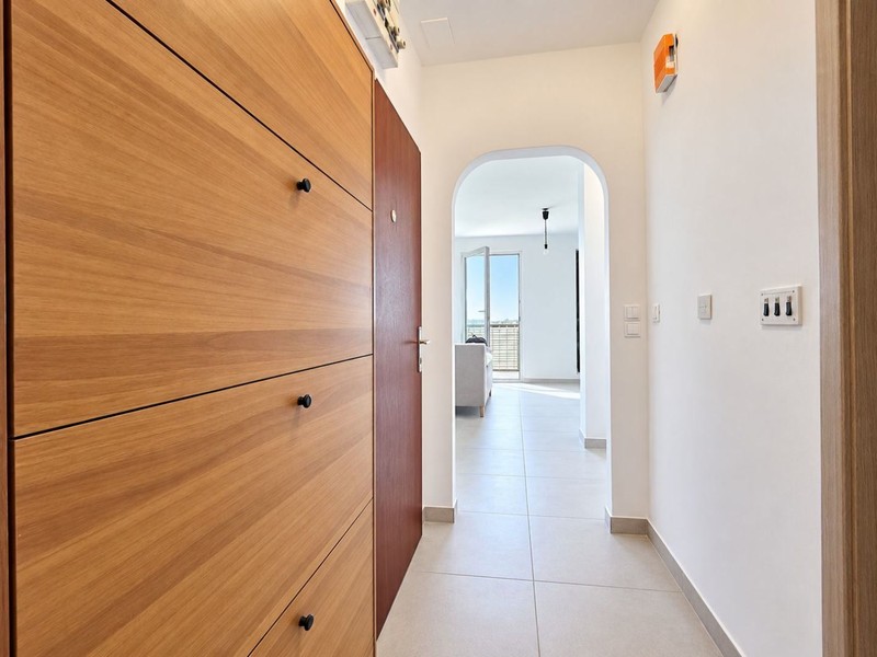 Hallway with wall cupboard and view into the living room