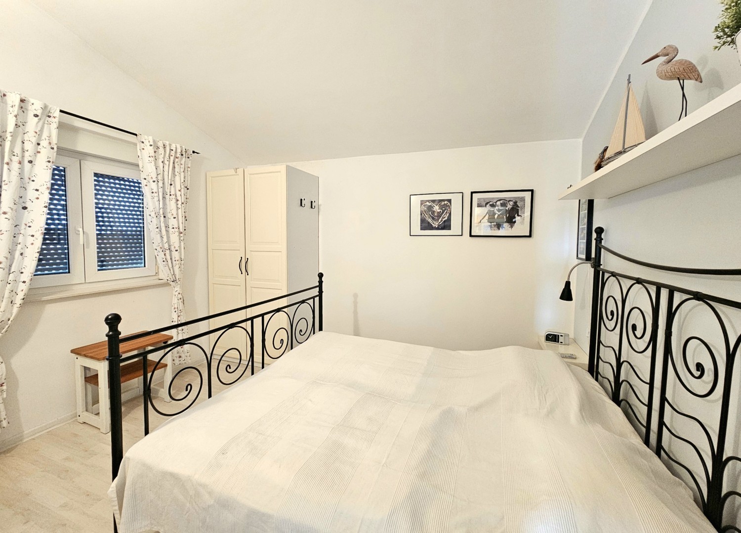 Bedroom with metal double bed under the sloping roof