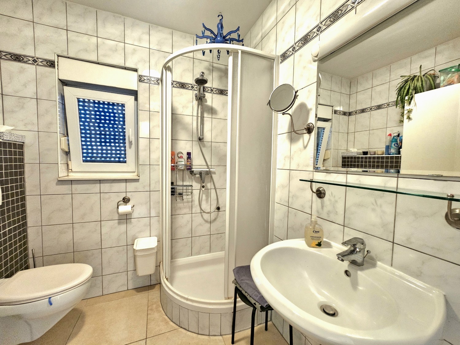 Bathroom with corner shower, washbasin and toilet