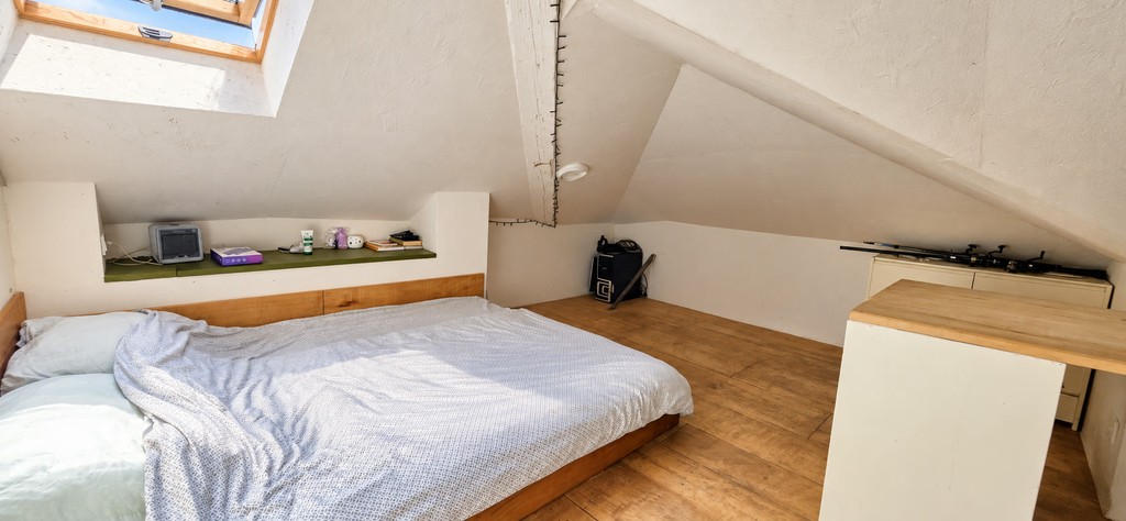 Attic room with bed under the sloping ceiling
