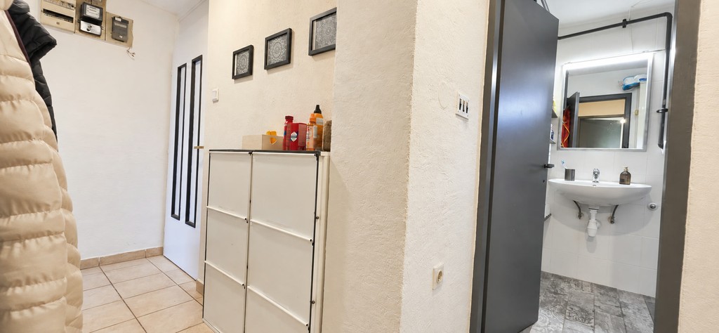 Hallway with cupboard and view into the bathroom