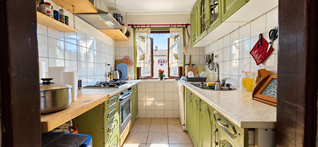 Kitchen with green cabinet fronts and window