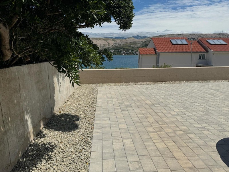 Paved courtyard with wall and sea view