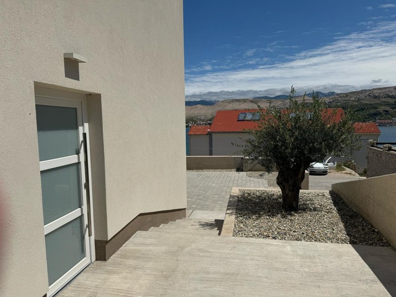 House entrance with olive tree and view of the sea