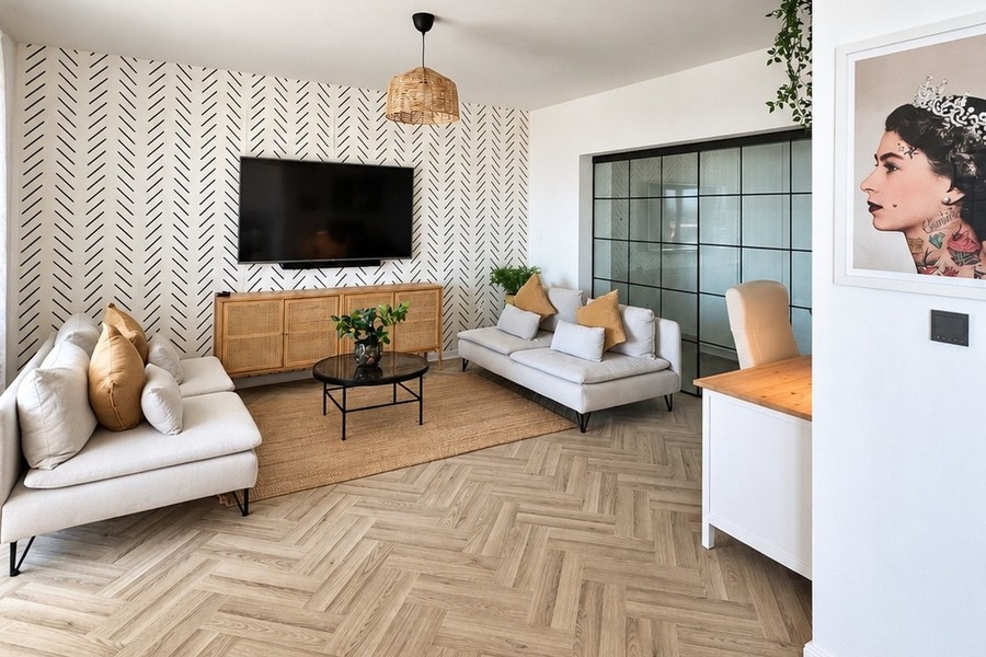 Living room with sofa, television and herringbone parquet flooring