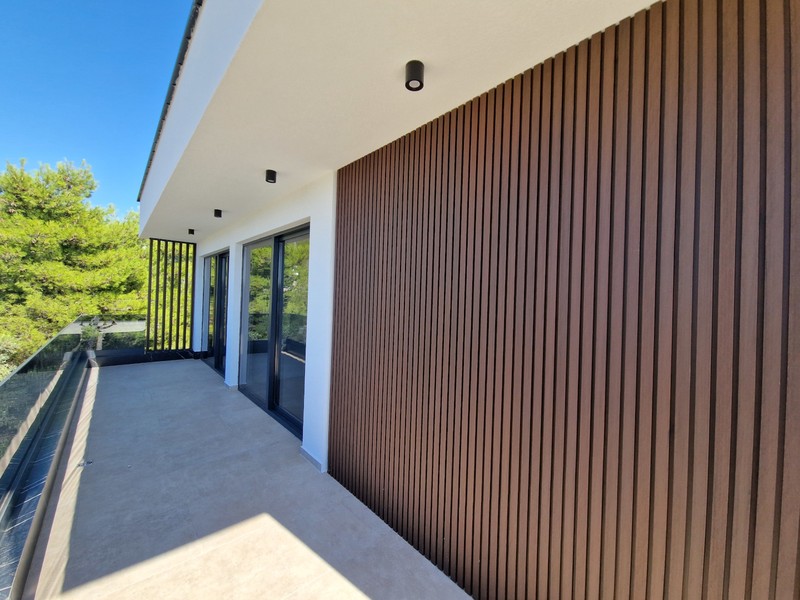 Loggia with wooden cladding and view of greenery